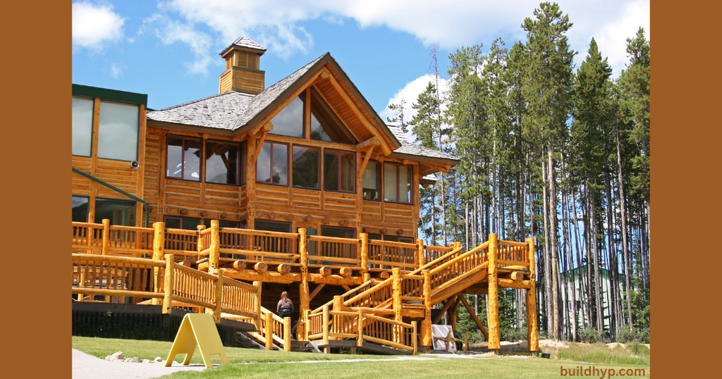 Exterior of a multi-level log cabin lodge featuring extensive wooden decks, outdoor stairs, and tall windows nestled among pine trees, representing grand mountain lodge house plans.