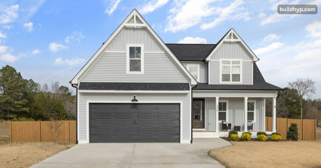 Spacious 2 story home design with light grey siding, steep gables, a wide two-car garage, and a covered front entryway.